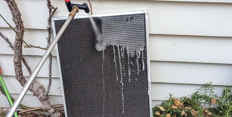 An air conditioner filter being cleaned